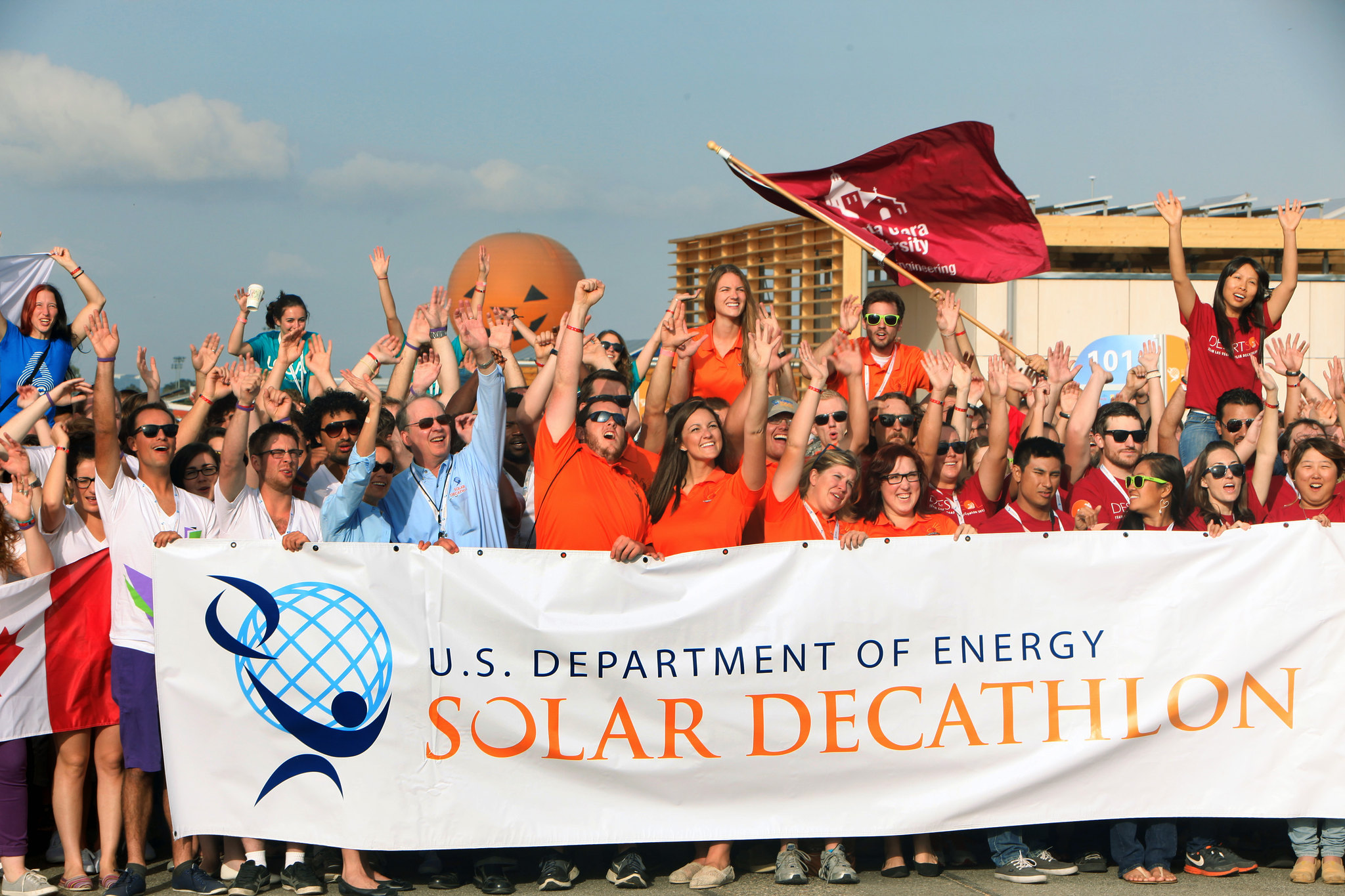 A group of people holding a solar decathlon banner.