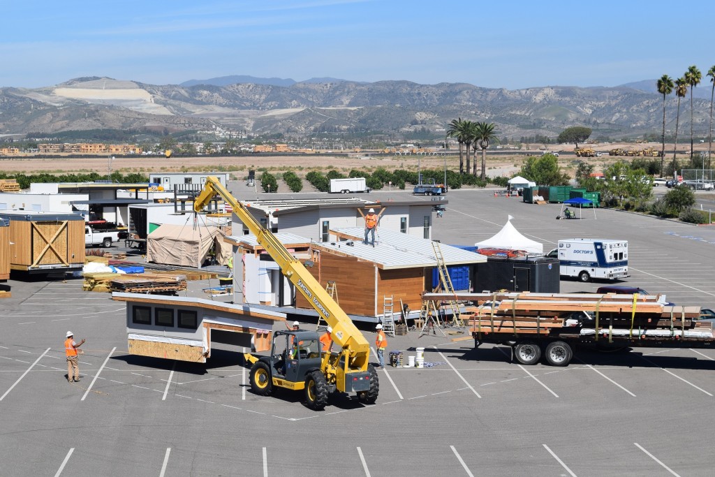 Aerial photo of the Solar Decathlon village during construction, showing a crane and several houses.