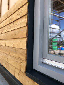 Picture of a home's exterior window with wooden framing panels partially installed.