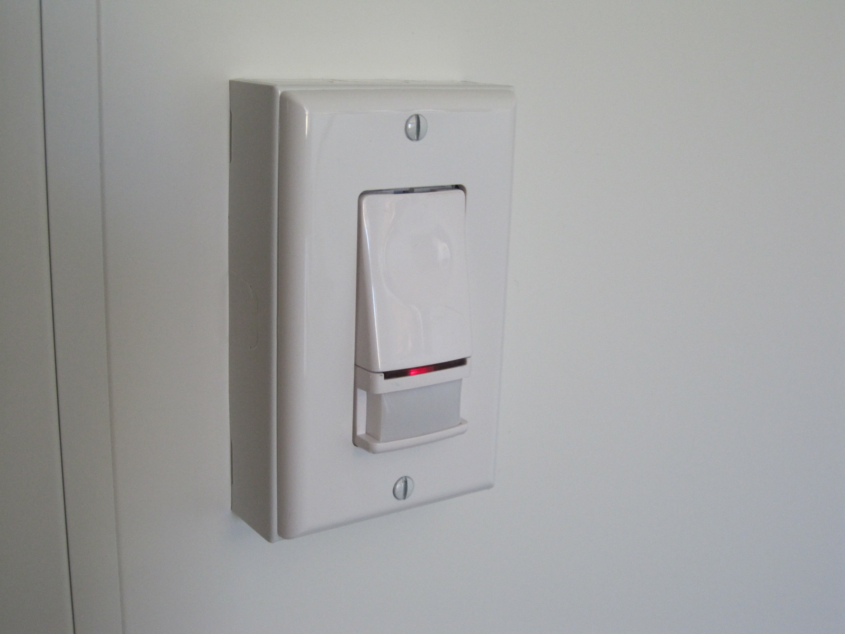 Photo of a vacancy sensor light switch on the wall.