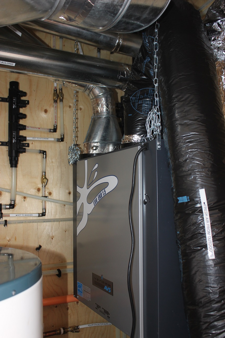 Photo of a box-shaped energy recovery ventilator inside a mechanical closet.