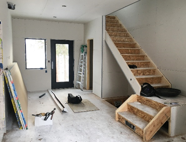 Inside view of a a new construction home, with unfished walls and stairs. 