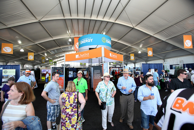 Photo of people walking through a large exhibit hall.
