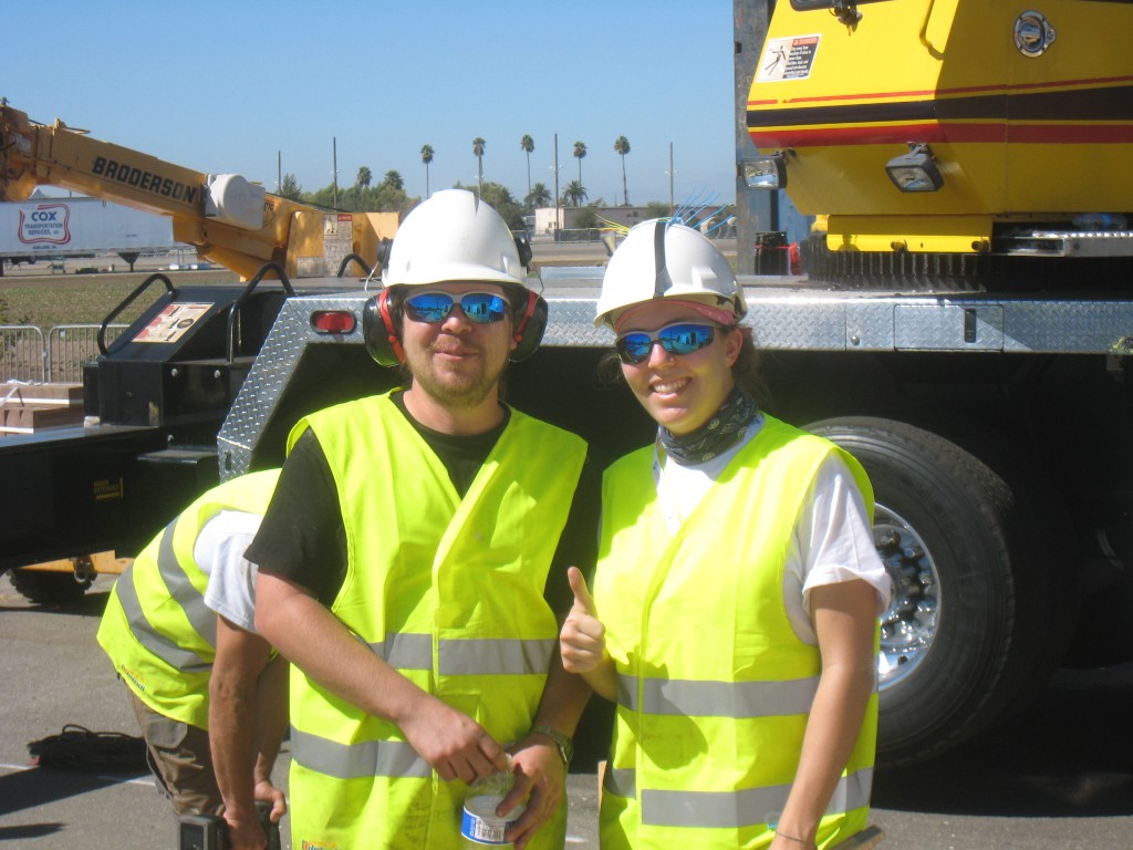 Photo of two decathletes wearing hard hats, safety glasses, and safety vests. 