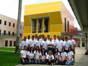 Photo of a group of students posing in front of a yellow building.