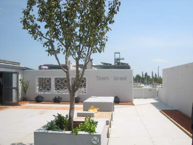 Photo of the inner courtyard of Team Israel’s house, which includes benches and potted trees.