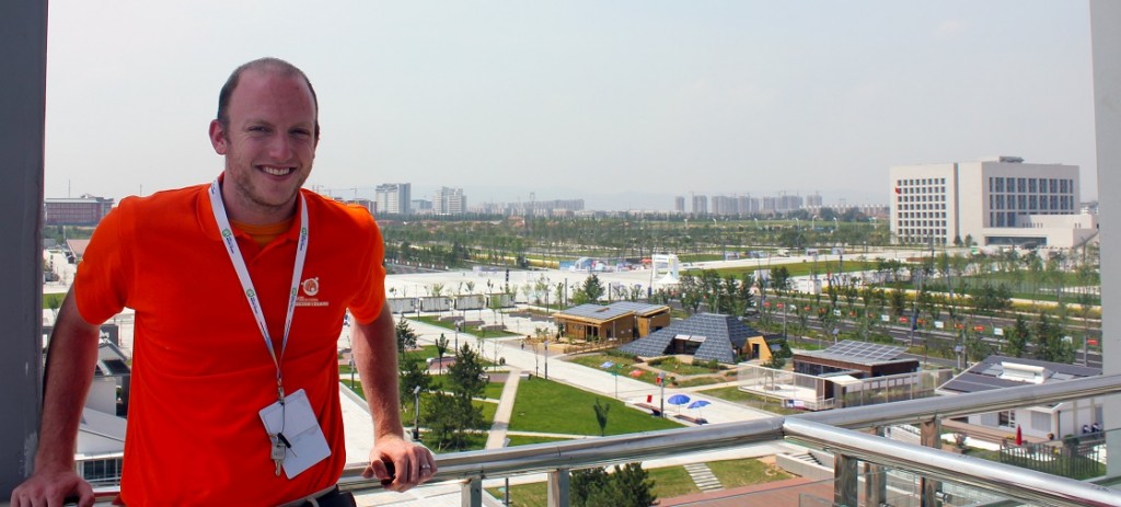 Photo of Joe Simon on balcony. The Solar Decathlon site is visible in the background.