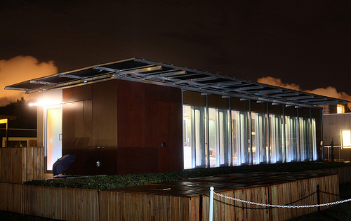 Photo of a solar-powered house lit up at night.