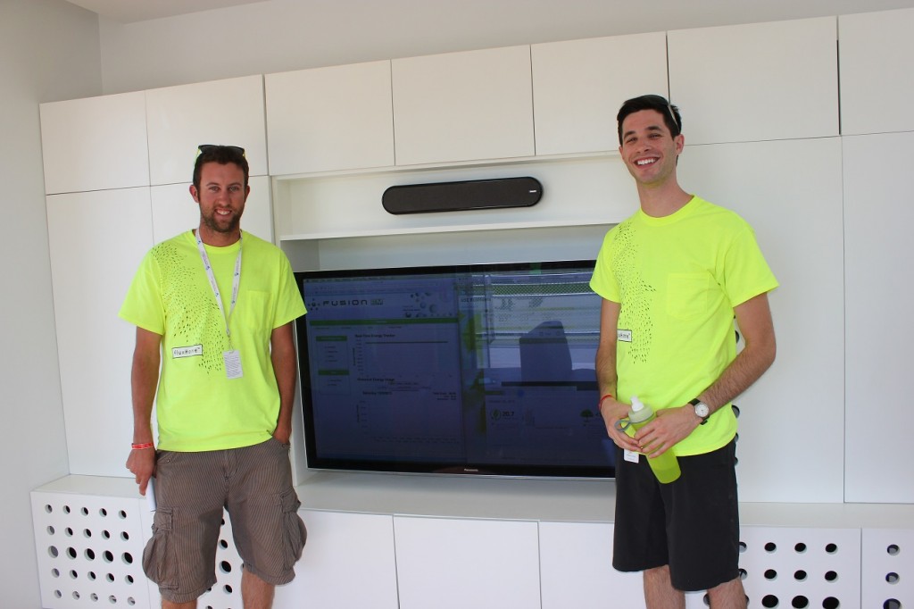 Photo of two decathletes standing on either side of a television.
