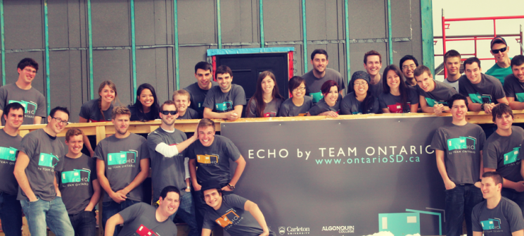 Photo of members of Team Ontario on the deck of their partially constructed house. 