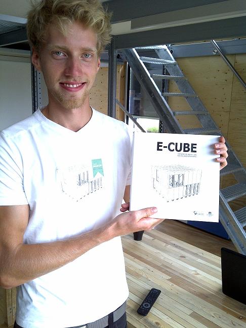 Photo of a man holding a book titled “E-Cube.”