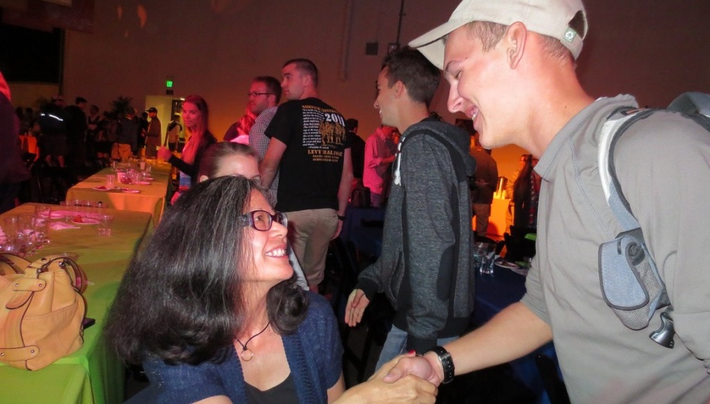 Photo of Vivian Stafford shaking the hand of a Norwich University student at a reception.
