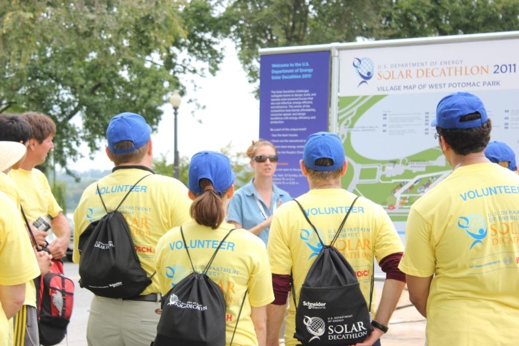 Photo of several volunteers gathered around a map of the solar village.