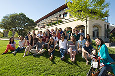 Photo of members of the Stanford University Solar  Decathlon 2013 team on a small hill in front of a campus building.