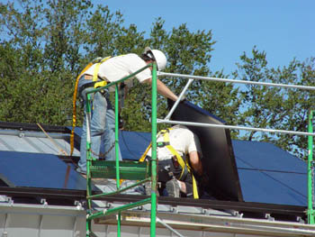 Photo of students installing photovoltaic panels on the University of Colorado Solar Decathlon solar house.