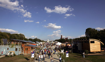 Photo of many people moving through the sunny solar village.