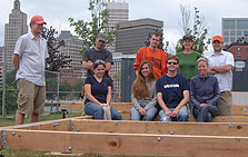 Photo of RISD's 2005 Solar Decathlon team sitting and standing around a wooden frame.