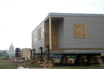 Photo of a solar home sitting about three feet off the ground on blocks of wood.