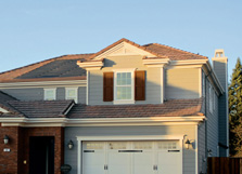 Photo of a suburban-style house with solar tiles integrated into a section of the roofing tiles.