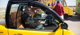 Photo of a man driving a electric vehicle.