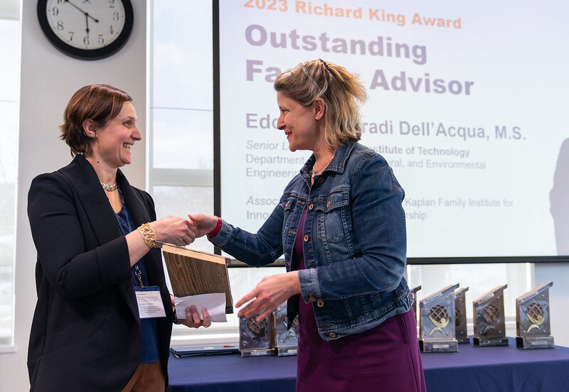 A photo of Holly Carr shaking hands with the 2023 Outstanding Faculty Advisor award winner: Edoarda Corradi Dell'Acqua