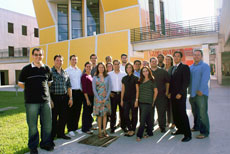 Photo of a group of people standing in front of a large, modern building.