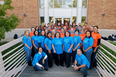 Photo of a group of people in matching blue and orange shirts.