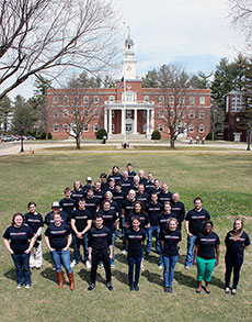 Photo of members of the Norwich University Solar  Decathlon 2013 team standing in front of a building on campus.