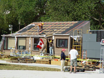 Photo of students installing photovoltaic panels on the Concordia University and Université de Montréal Solar Decathlon solar house.