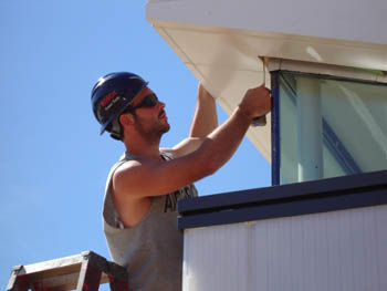 Photo of a student working on the roof of his Solar Decathlon solar house.