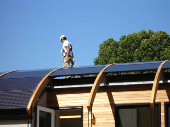 Photo of students installing photovoltaic panels on the University of Maryland Solar Decathlon solar house.