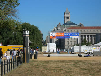 Photo of the sign for the Smithsonian Metro station on the National Mall in Washington. D.C. In the background a larger banner welcomes visitors to the 2005 Solar Decathlon.