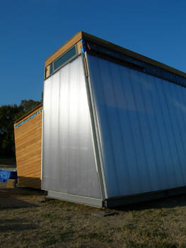 Photo of the Pittsburgh Synergy Solar Decathlon solar house on the National Mall. The photo shows a tilted wall made of sheets of polycarbonate, a strong, insulating plastic that is embedded with glass beads.