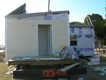 Photo of University of Massachusetts Dartmouth drilling a hole in the ground for electrical purposes as part of the 2005 Solar Decathlon.