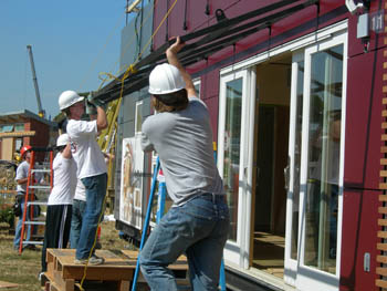 Photo of CalPoly students installing an awning on their Solar Decathlon solar house. 