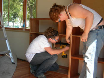 Photo of two students installing cabinets on their 2005 Solar Decathlon house.