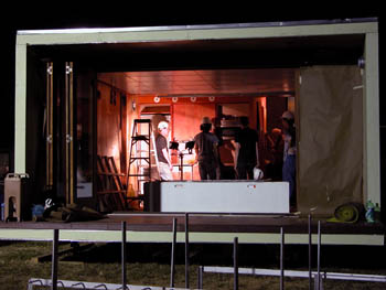 Photo of four men working under construction lights in a home.