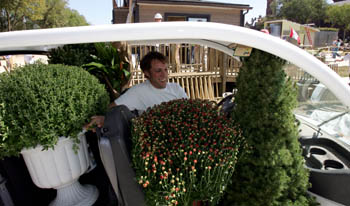 Photo of man and plants in small electric car.