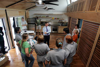Photo of a congressman from Texas talking with several students inside the University of Texas Solar Decathlon house.