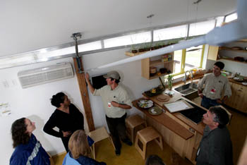Photo of a group of people looking at roof system from inside the house.