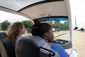 Photo of two women driving an electric vehicle.