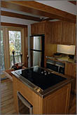 Photo of kitchen with wood floor, trim, and cabinetry.