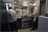 Photo of two chefs preparing food in a kitchen.