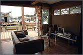 Photo of living room with outdoor deck visible through doors.
