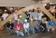 Photo of Michigan's 2005 Solar Decathlon team wearing hardhats and gathered around a structural element.