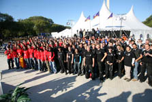 Photo of several hundred young people, the 2007 Solar Decathlon team members, posed for a group photo and standing in front of a large white tent.
