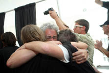 hoto of three team members hugging.