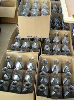 Photo of a stack of packing boxes filled with glass milk bottles.