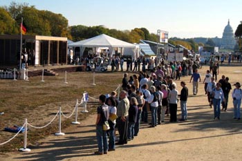 Aerial photograph of a long line of people forming a line around a solar house.
