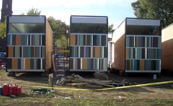 Photo of a solar home divided into three cubicle pieces and sitting on blocks.